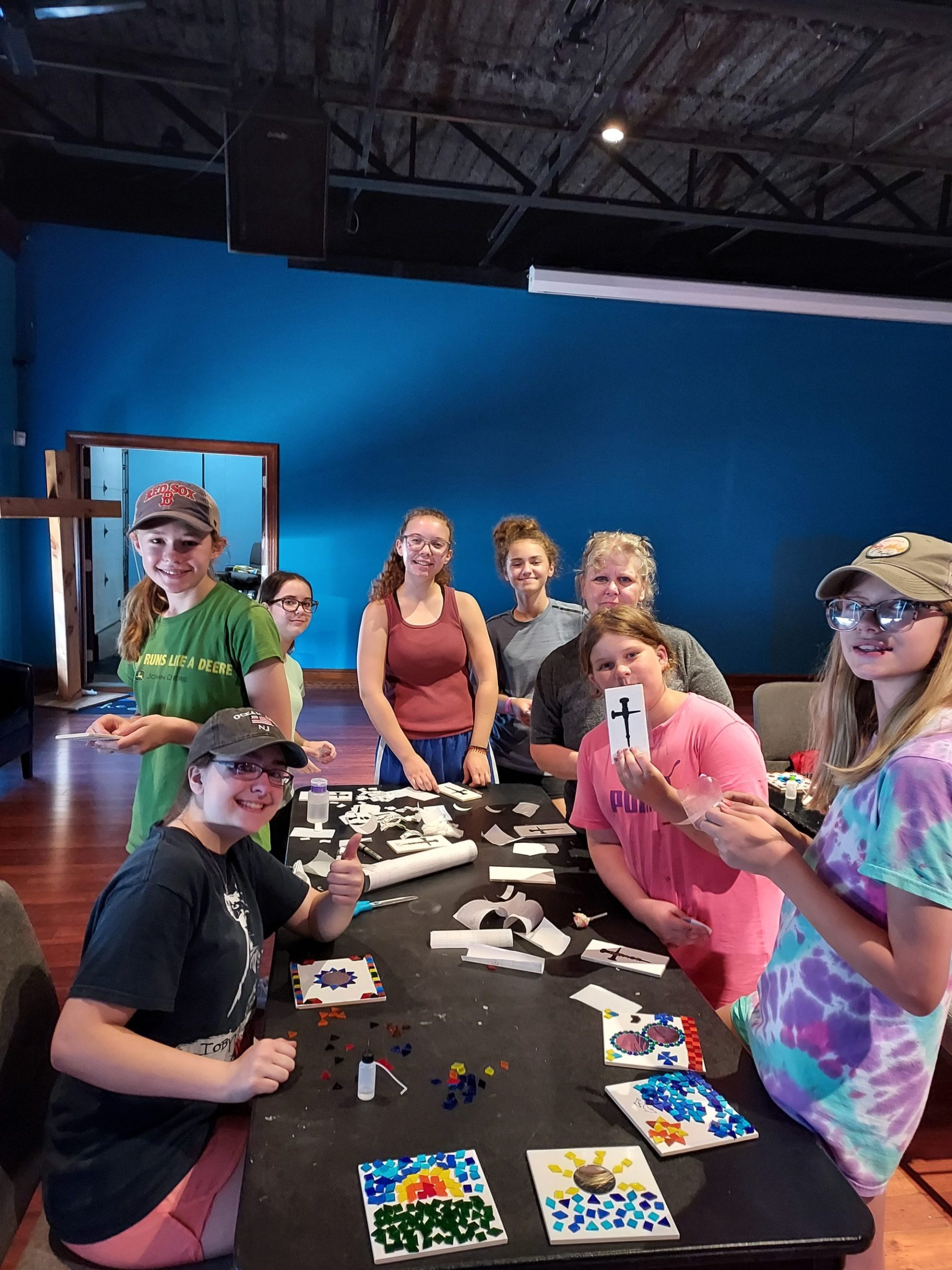 some teens working on arts and crafts at a table in the journey