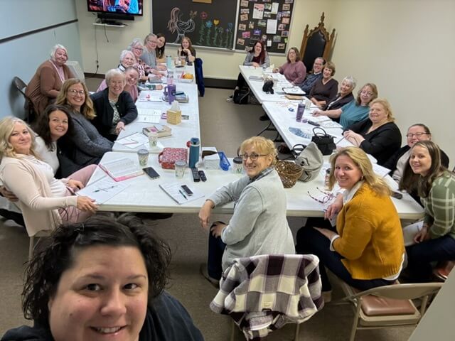 women sitting around a table in a classroom